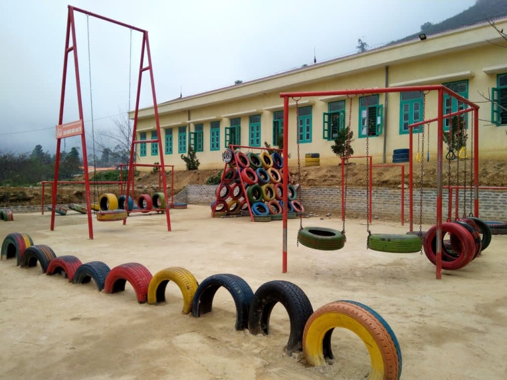 Toàn cảnh sân chơi lốp xe tái chế với xích đu, cầu treo và các hạng mục vận động tại điểm trường vùng cao